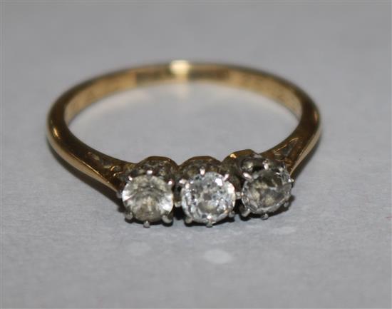 A 1930s 18ct gold and platinum three stone diamond ring, size M.